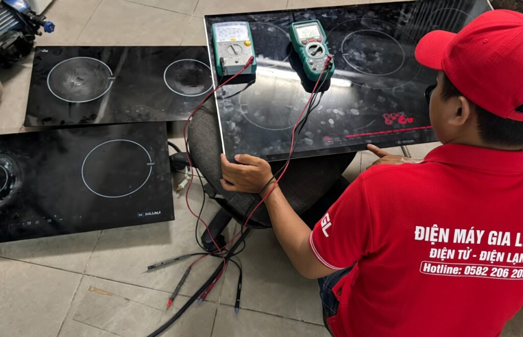 kỹ thuật viên đang thay linh kiện bếp từ